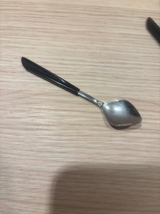 Nilsjohan Inga kaffesked närbild, visar det svarta handtaget och den polerade rostfria skålen
